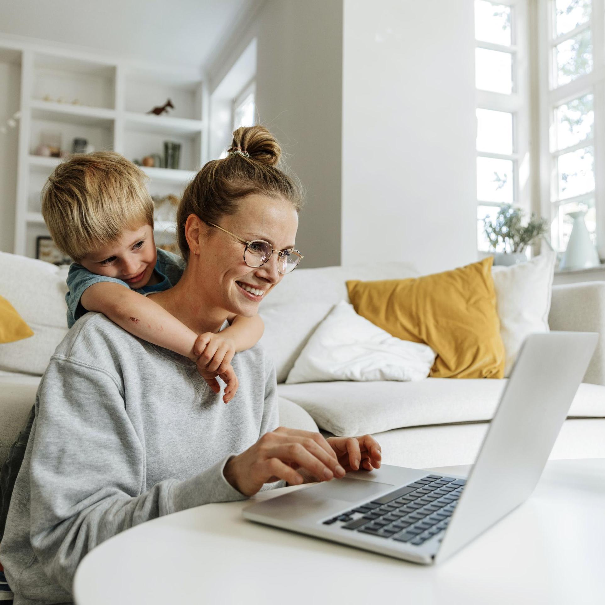 Mother and child using a laptop together in their living room