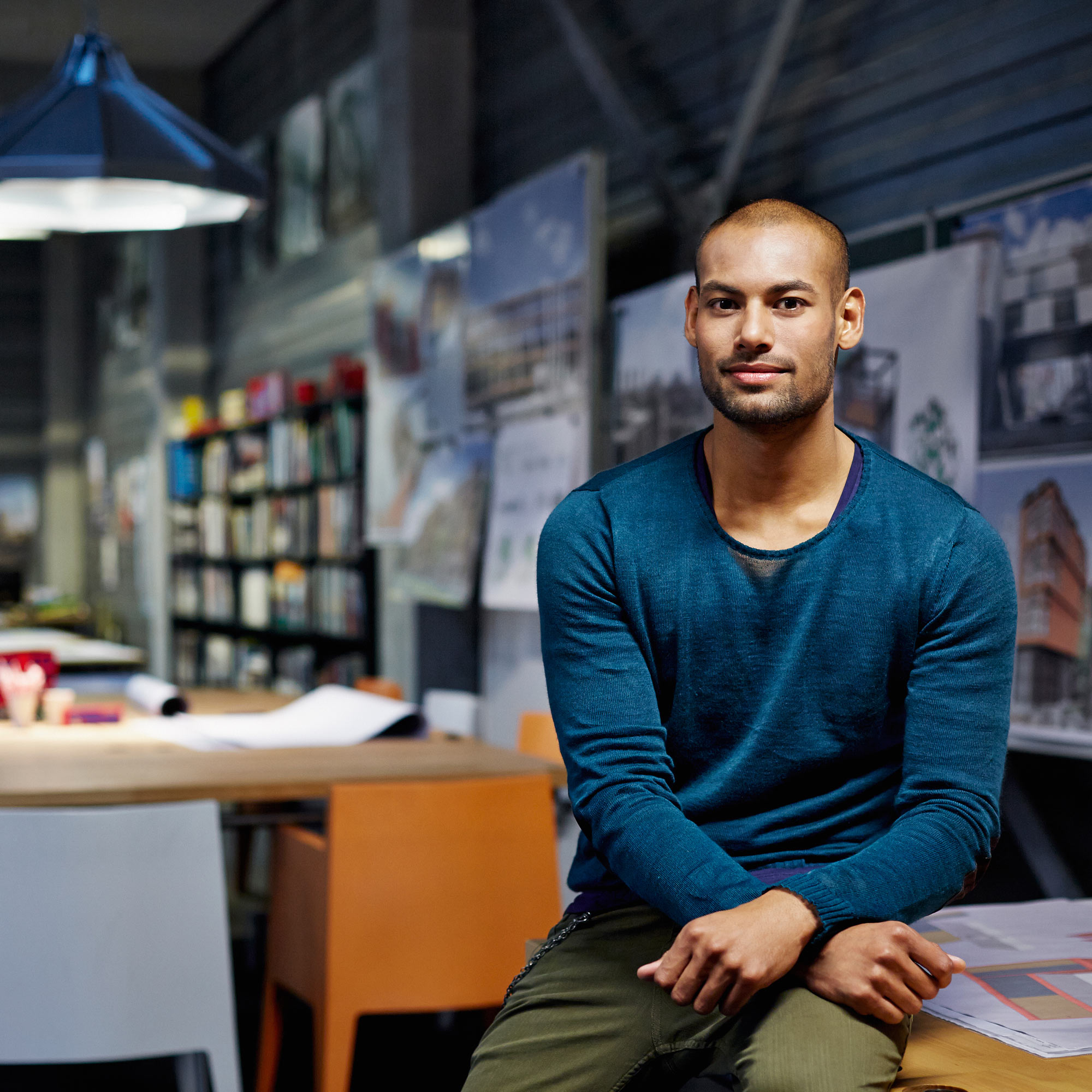 Man med blå tröja sitter på ett arkitektkontor