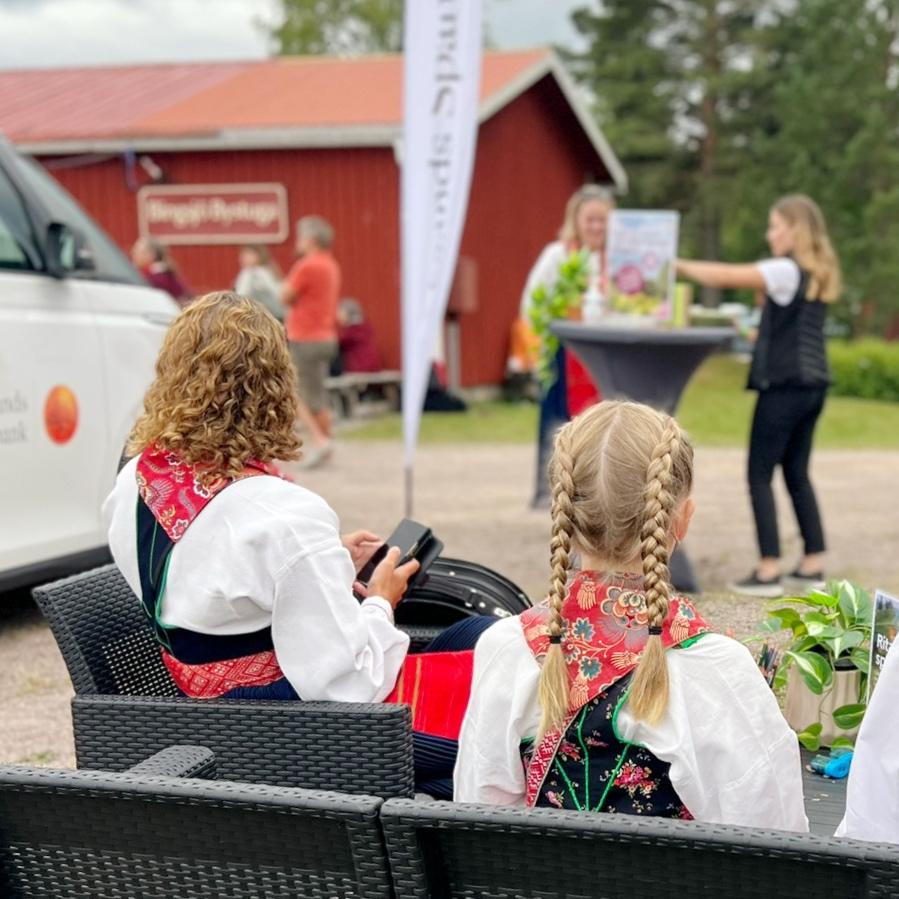 Tre dräktklädda kvinnor besöker Leksands Sparbanks sparbanksbuss under ett stopp i Rättvik.